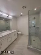 a bathroom with a granite countertop sink a toilet and a shower