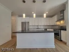 a kitchen with stainless steel appliances granite countertop a refrigerator a sink a stove and a microwave