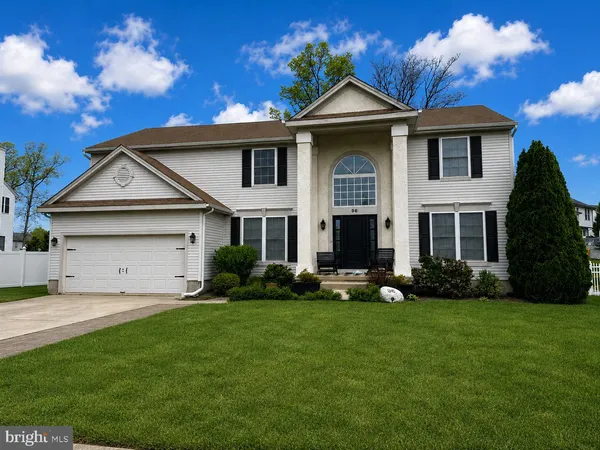 a front view of a house with a garden and yard