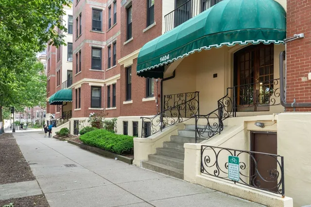 a street sign on a sidewalk next to a building