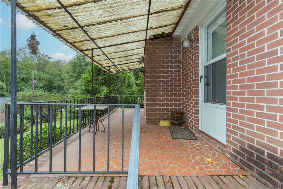 118 Blair Road Belton, SC 29627 - Photo 38 of 49 An elevated patio with stone tile flooring overlooks the surrounding mature trees.