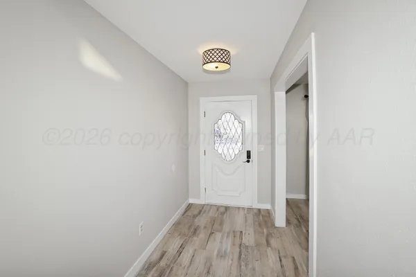 a view of empty room with wooden floor