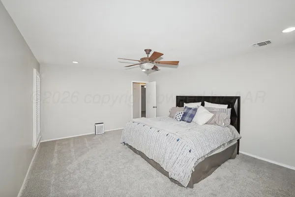a bedroom with a bed and a ceiling fan