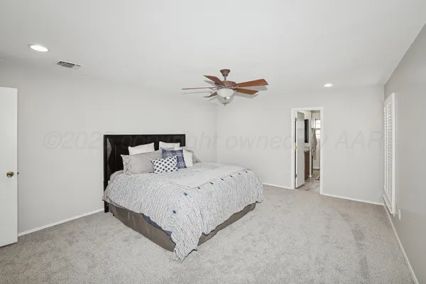 a bedroom with a bed and a ceiling fan
