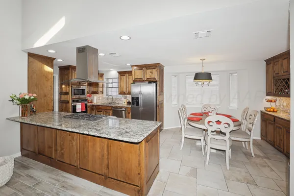 a kitchen with stainless steel appliances granite countertop a sink and a refrigerator