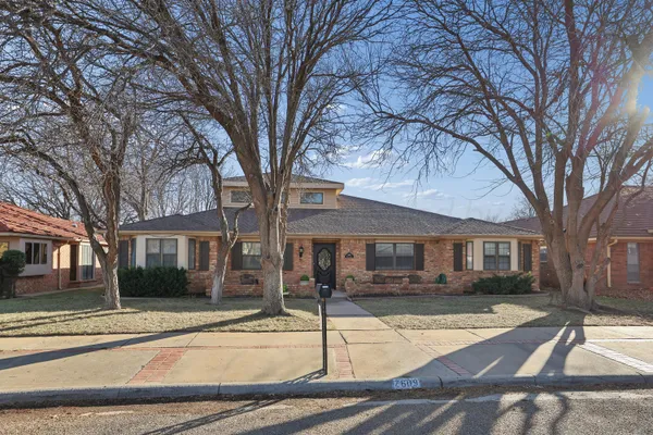 a front view of residential houses with yard and trees