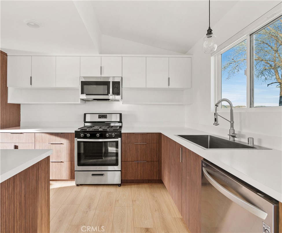 a kitchen with granite countertop a sink and steel appliances