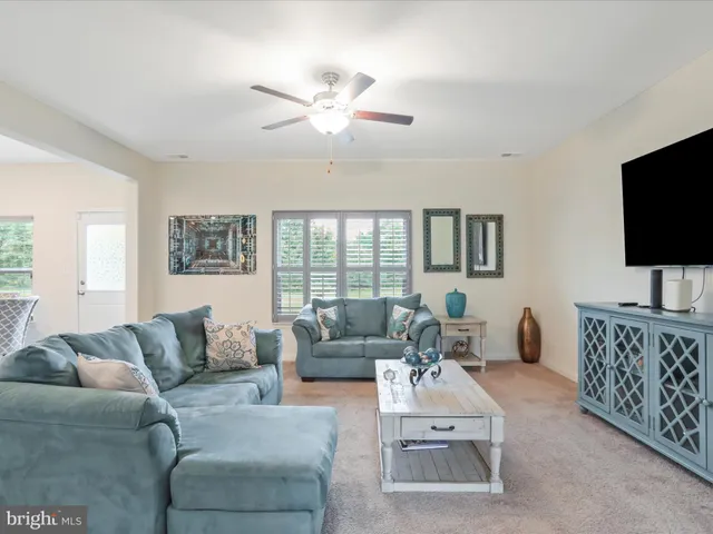 a living room with furniture a flat screen tv and a window