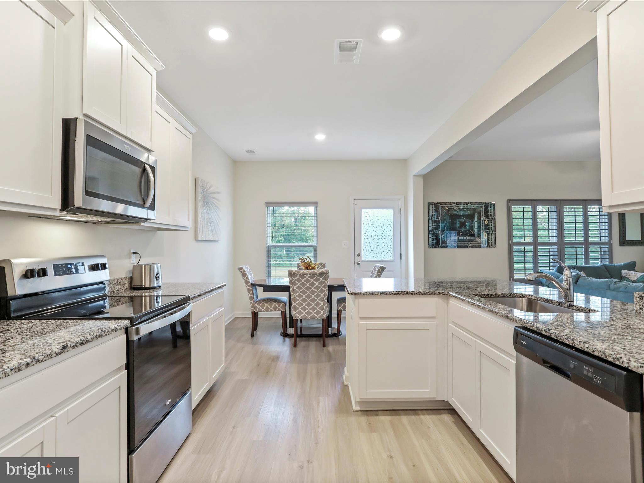 208 Rappahannock Run Falling Waters, WV 25419 - Photo 6 of 44 a kitchen with stainless steel appliances granite countertop wooden cabinets a sink dishwasher a stove and a refrigerator with wooden floor