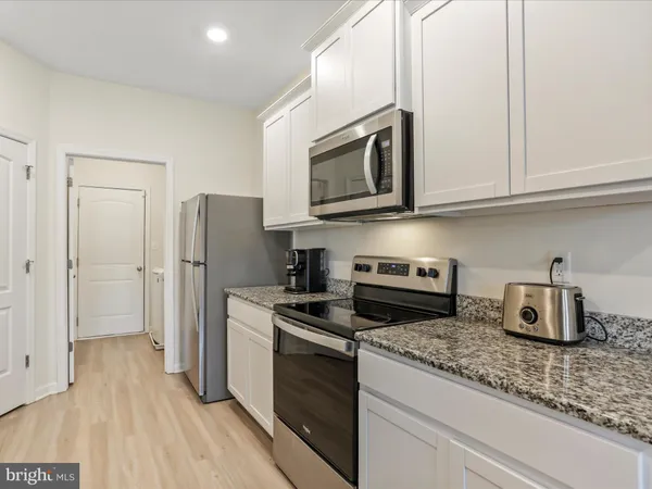 a kitchen with stainless steel appliances granite countertop a refrigerator stove and microwave