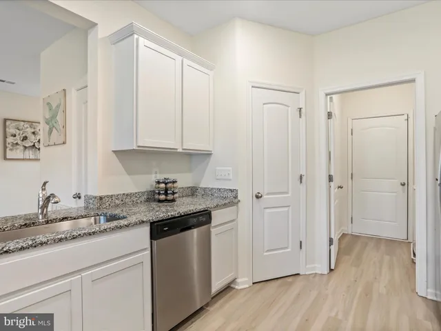 a kitchen with stainless steel appliances granite countertop a sink and wooden cabinets