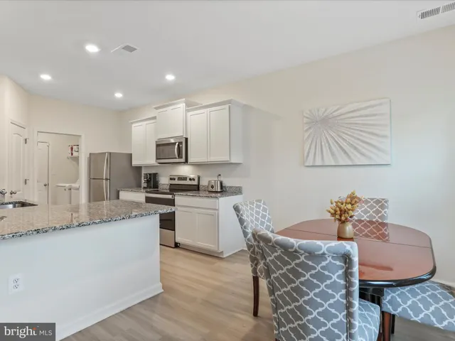 a kitchen with granite countertop white cabinets stainless steel appliances and sink