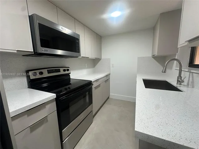 a kitchen with a sink and a stove top oven