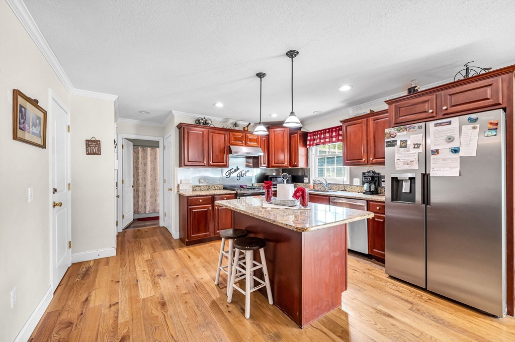 31 Acrebrook Road Springfield, MA 01129 - Photo 8 of 42 a kitchen with stainless steel appliances granite countertop a refrigerator a sink dishwasher a stove and a dining table with wooden floor