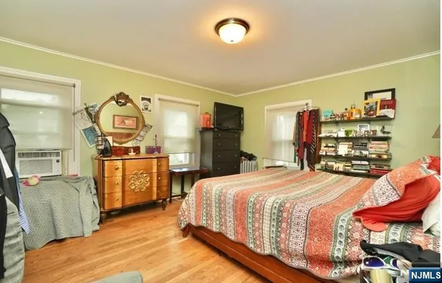 a bedroom with a bed and dresser with mirror