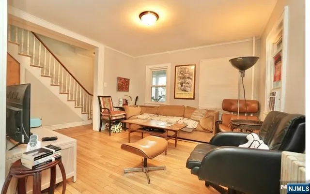 a living room with furniture and a flat screen tv with wooden floor