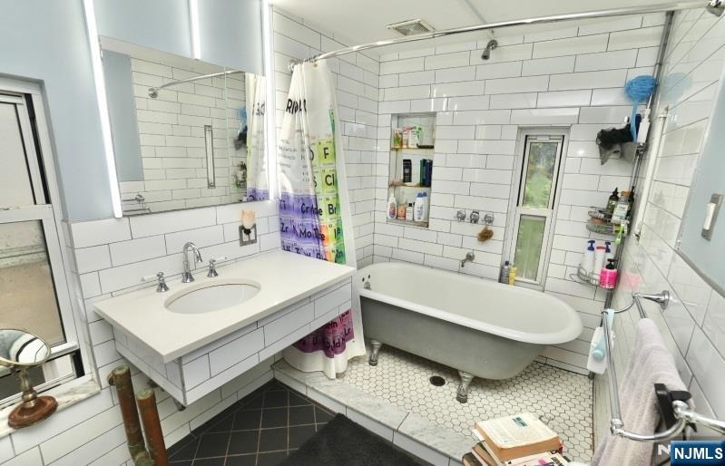 13 Thomas Street Bloomfield, NJ 07003 - Photo 9 of 18 a bathroom with a sink and a mirror