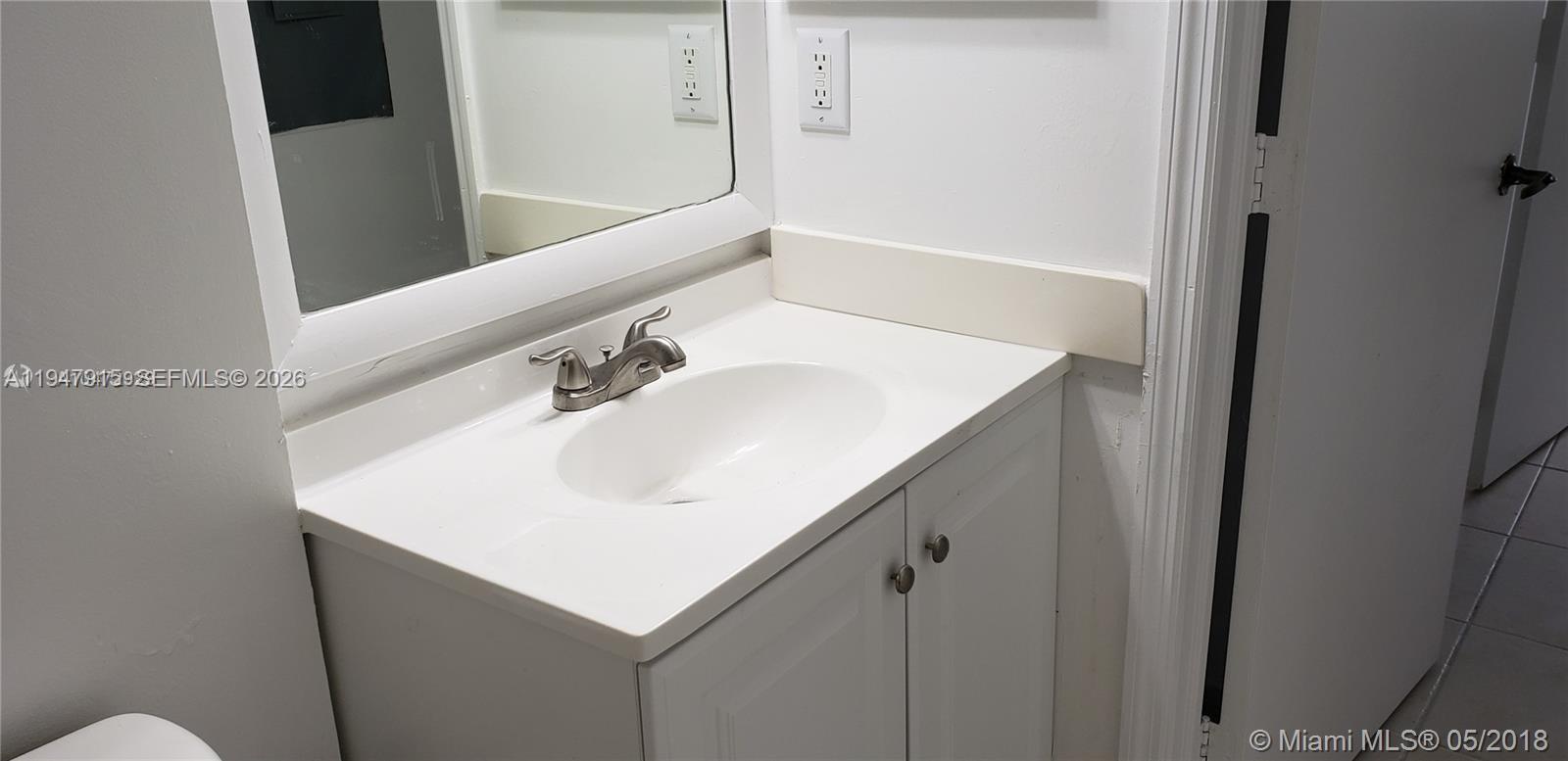 17901 Northwest 68th Avenue, Unit Q201 Hialeah, FL 33015 - Photo 5 of 6 a bathroom with a sink and a mirror