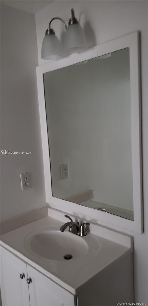 17901 Northwest 68th Avenue, Unit Q201 Hialeah, FL 33015 - Photo 6 of 6 a bathroom with a sink and mirror