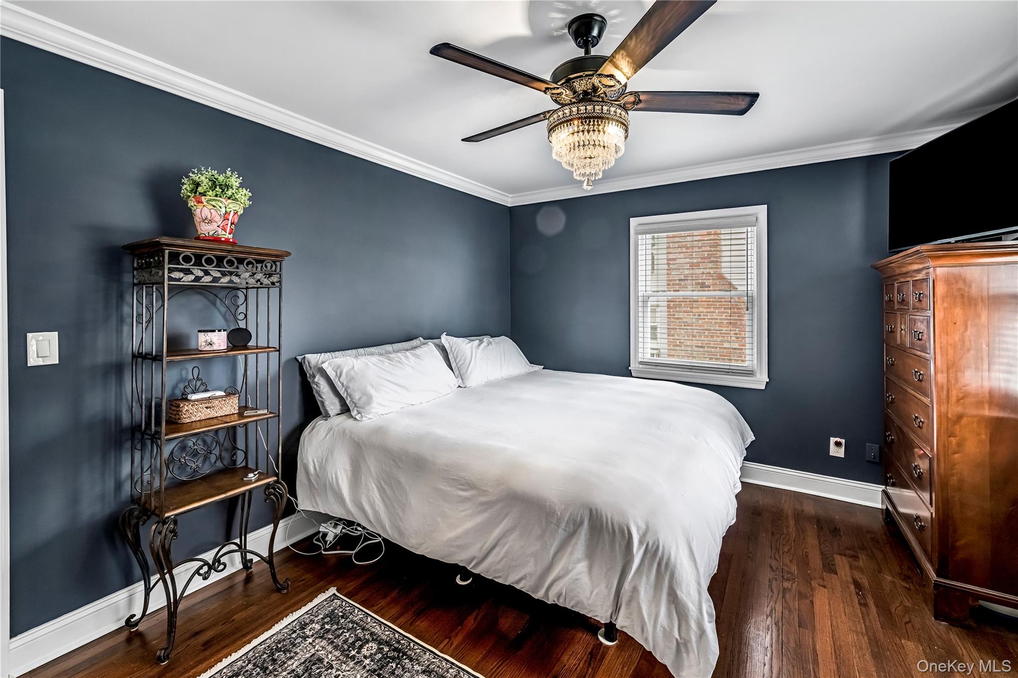 40 Wickford Road New Rochelle, NY 10801 - Photo 19 of 32 a bedroom with a bed a window and a chandelier