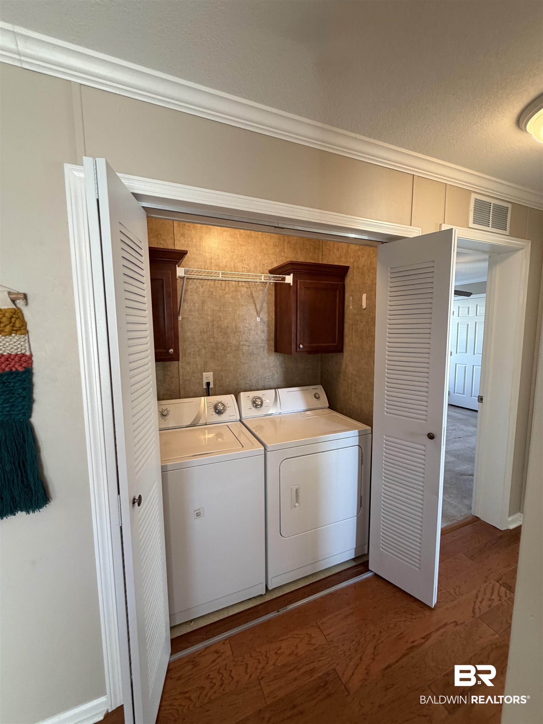 675 Escambia Loop Lillian, AL 36549 - Photo 21 of 44 Washroom featuring cabinet space, crown molding, separate washer and dryer, and dark wood-style flooring