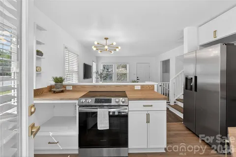a kitchen with a stove cabinets and wooden floor
