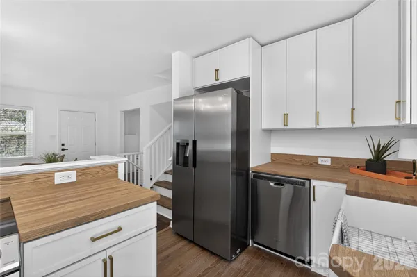 a kitchen with granite countertop a refrigerator and a sink