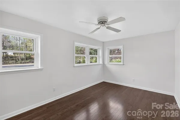 a view of a big room with wooden floor and windows