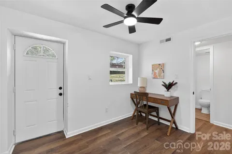 a view of a workspace with wooden floor and a ceiling fan