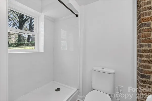 a bathroom with a toilet and a shower