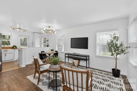 a living room with furniture a chandelier and a flat screen tv
