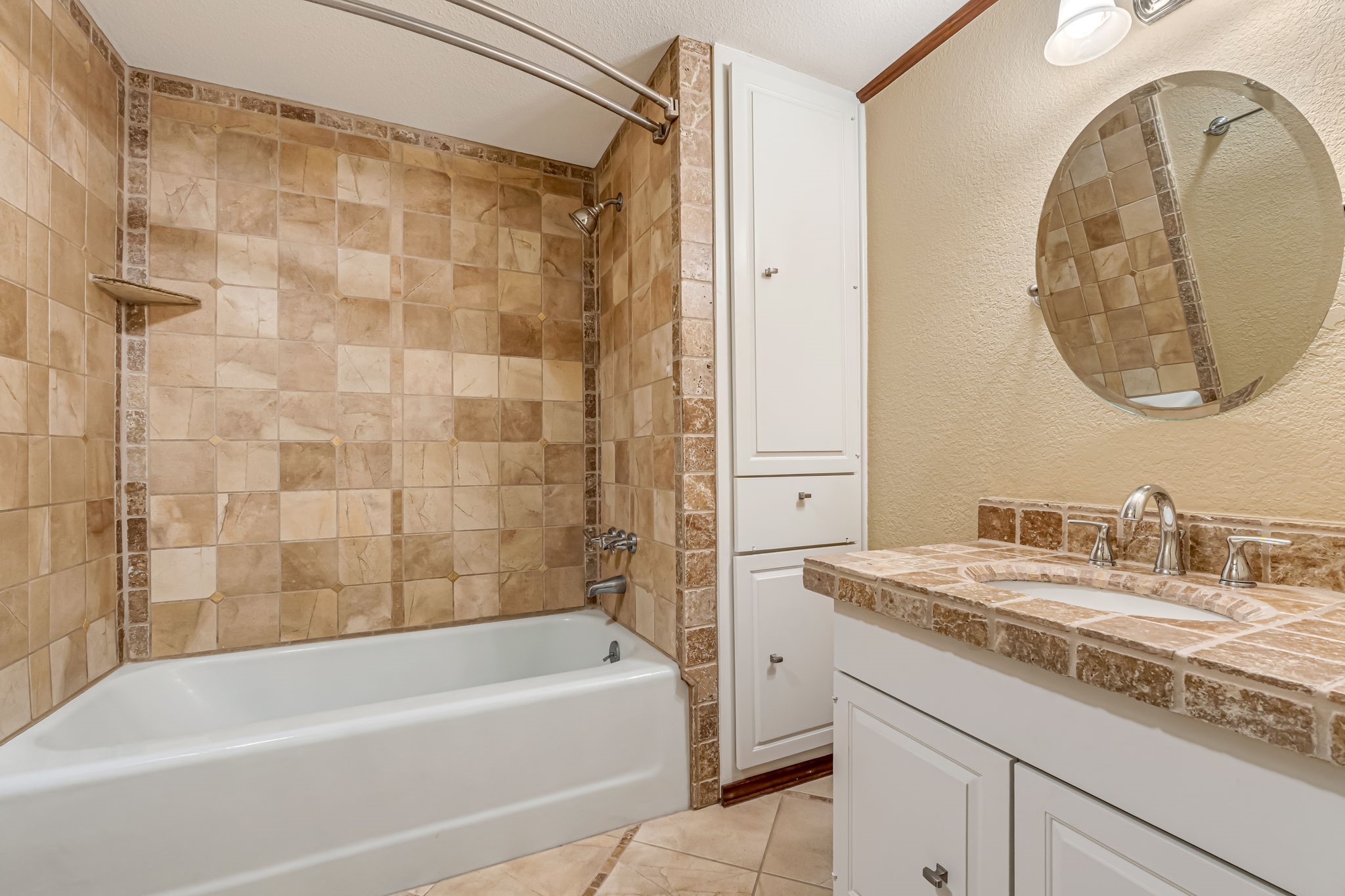516 South Post Oak Lane, Unit 18 Houston, TX 77056 - Photo 17 of 20 Secondary bath with tub and shower combination, vanity with tile countertop, and built-in storage cabinetry.
