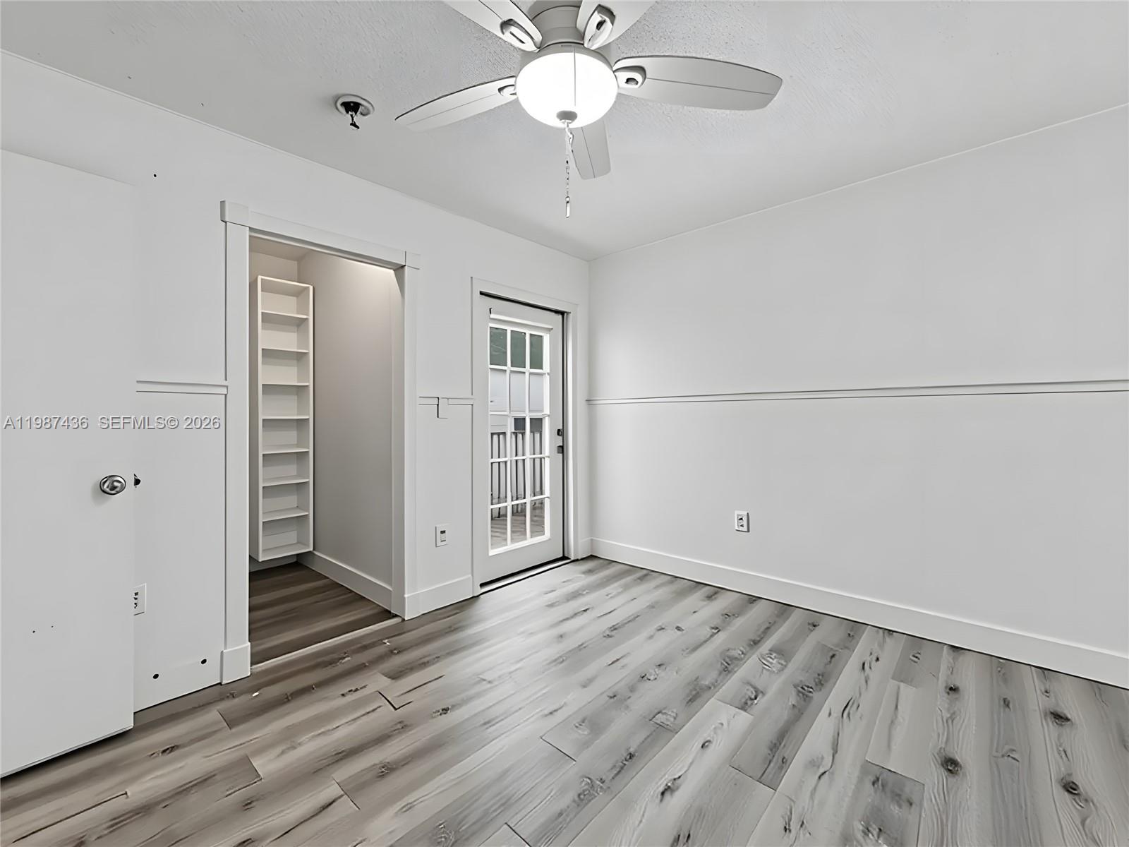 16004 Southwest 87th Terrace Miami, FL 33193 - Photo 18 of 30 an empty room with wooden floor chandelier fan and windows