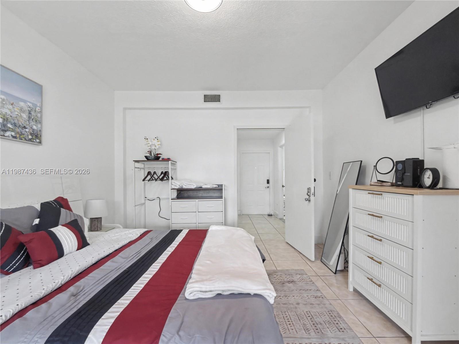 16004 Southwest 87th Terrace Miami, FL 33193 - Photo 6 of 30 a bedroom with a bed and flat screen tv