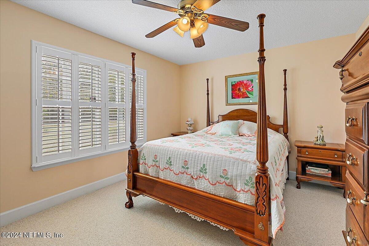 9058 Butcher Road Glen St. Mary, FL 32040 - Photo 28 of 43 a bedroom with a bed and a chandelier