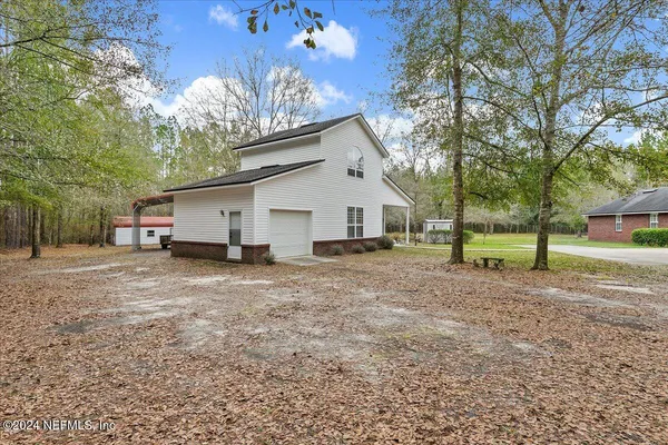 a backyard of a house with a swing table and chairs