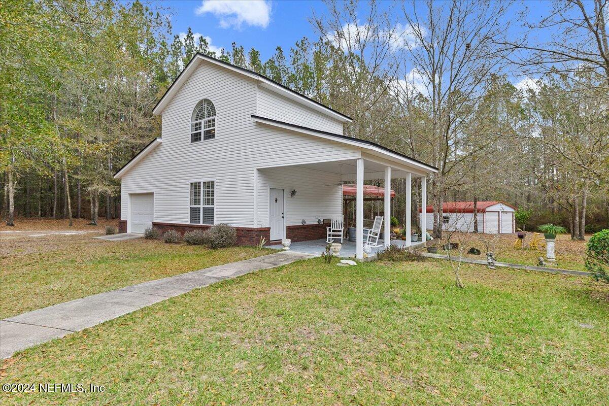 9058 Butcher Road Glen St. Mary, FL 32040 - Photo 5 of 43 a view of a house with a yard patio and fire pit