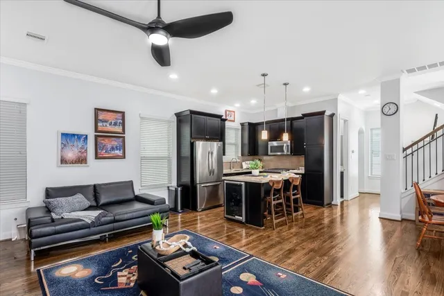 a kitchen with stainless steel appliances granite countertop a refrigerator a stove and a dining table with wooden floor