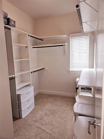 a view of walk in closet with clothes and shoes