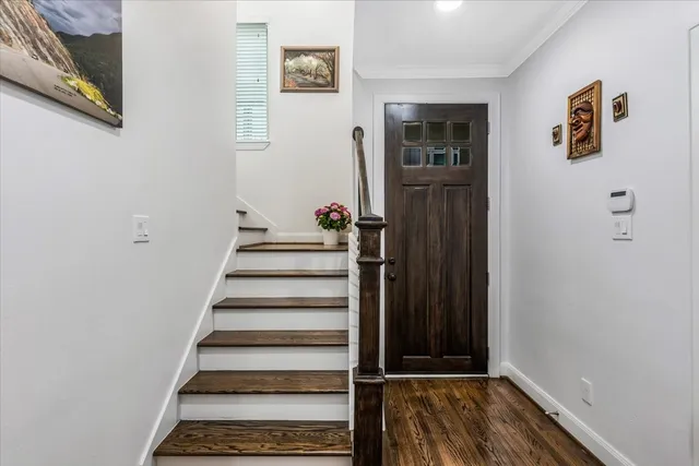 a view of a hallway with wooden floor and entryway