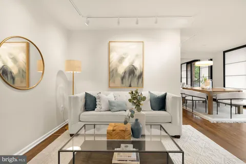 a living room with furniture and large windows with wooden floor