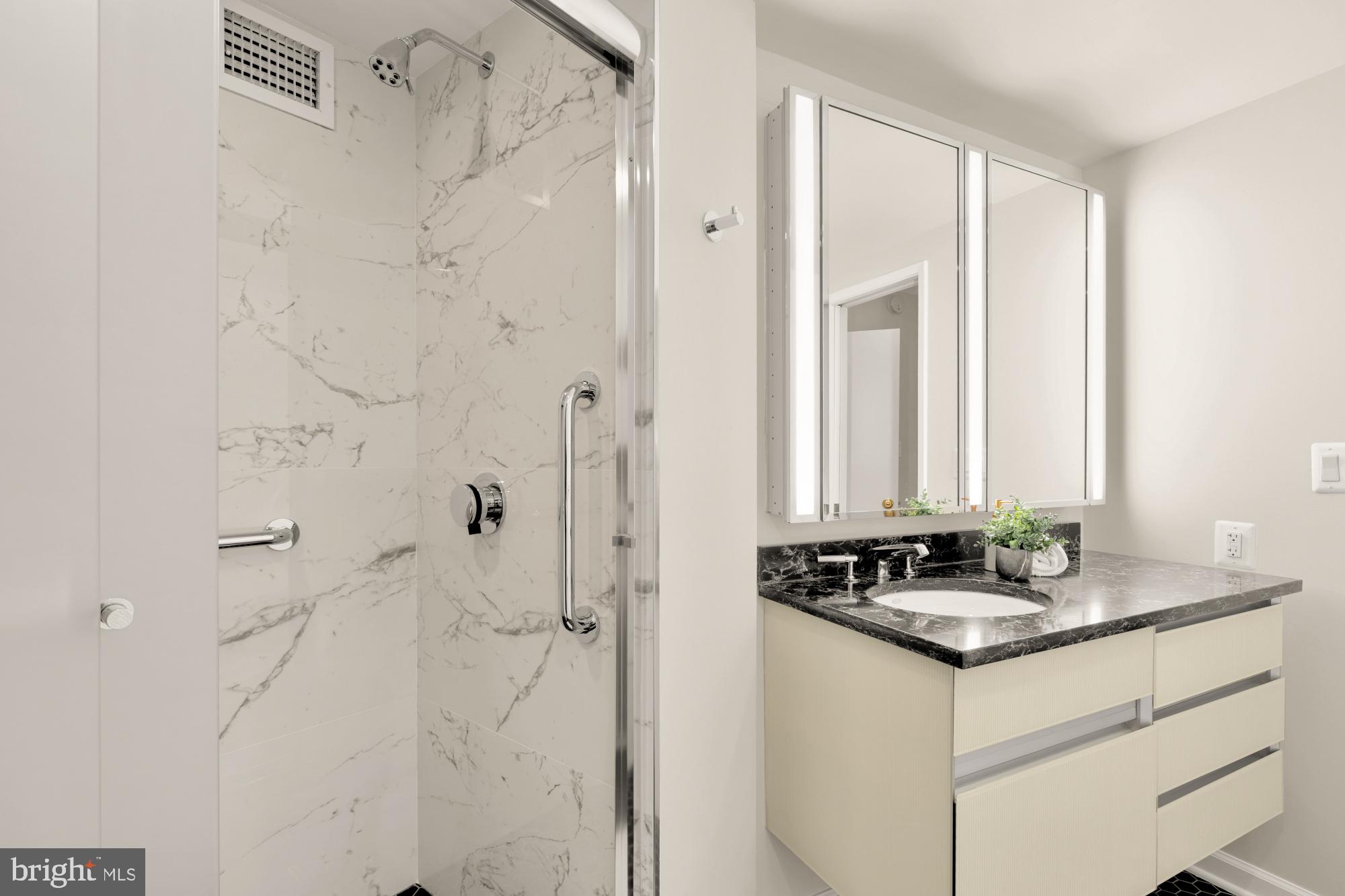 2555 Pennsylvania Avenue Northwest, Unit 617 & 618 Washington, DC 20037 - Photo 33 of 56 a bathroom with a granite countertop sink and a mirror