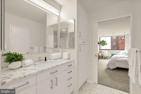 a living room with furniture a large window and a potted plant