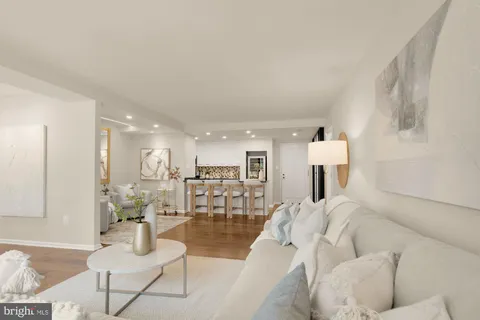 a living room with furniture and a dining table with wooden floor