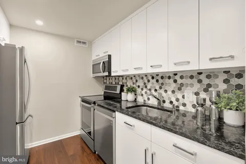 a bathroom with a granite countertop double vanity sink and a mirror