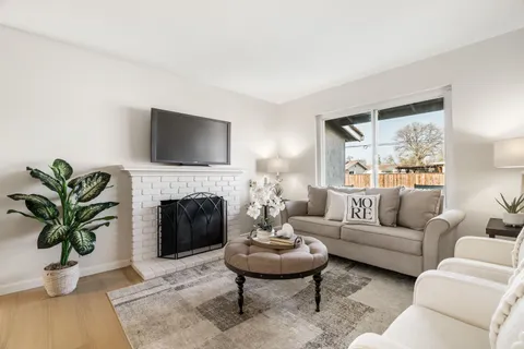 a living room with furniture a fireplace and a flat screen tv