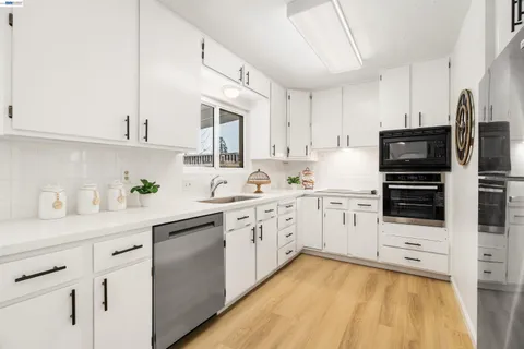 a kitchen with stainless steel appliances a sink stove refrigerator and cabinets