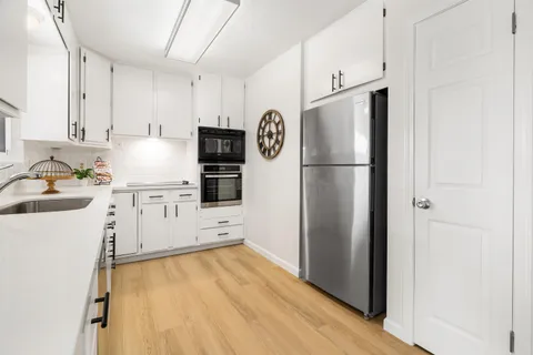 a kitchen with a refrigerator sink stove and cabinets