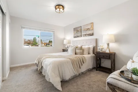 a spacious bedroom with a bed and a lamp