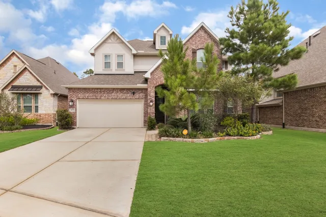 a front view of a house with a yard and garage